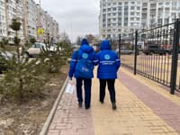 Members of the precinct election commission carry a ballot box
