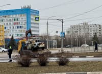 Municipal workers haul away cars damaged in the shelling