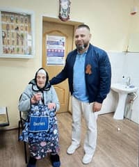 Aleksandr Garkavenko poses for a photo with an elderly local resident.