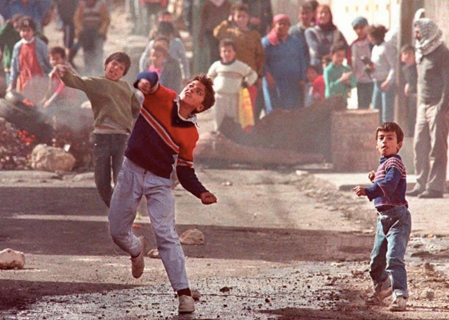Palestinian children throw stones at the Israeli military