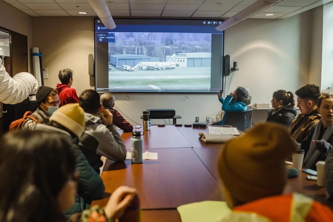 Immigration lawyers at the University of Washington watch a live broadcast of boarding for a deportation flight at Boeing Field airport