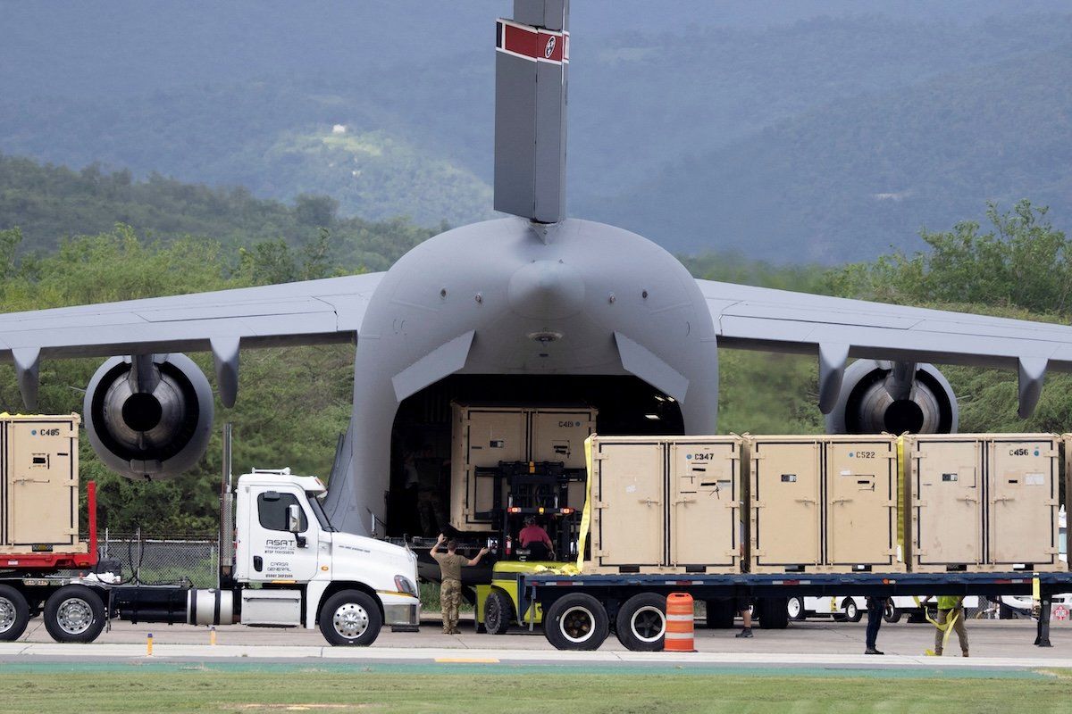 Экипажи загружают груз на грузовой самолет C-17 в международном аэропорту Мерседита. Фото: Reuters